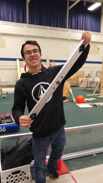 A student posing with his first milled part (a drive rail)