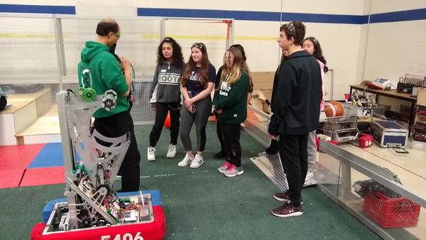 Showing new students how to change robot batteries